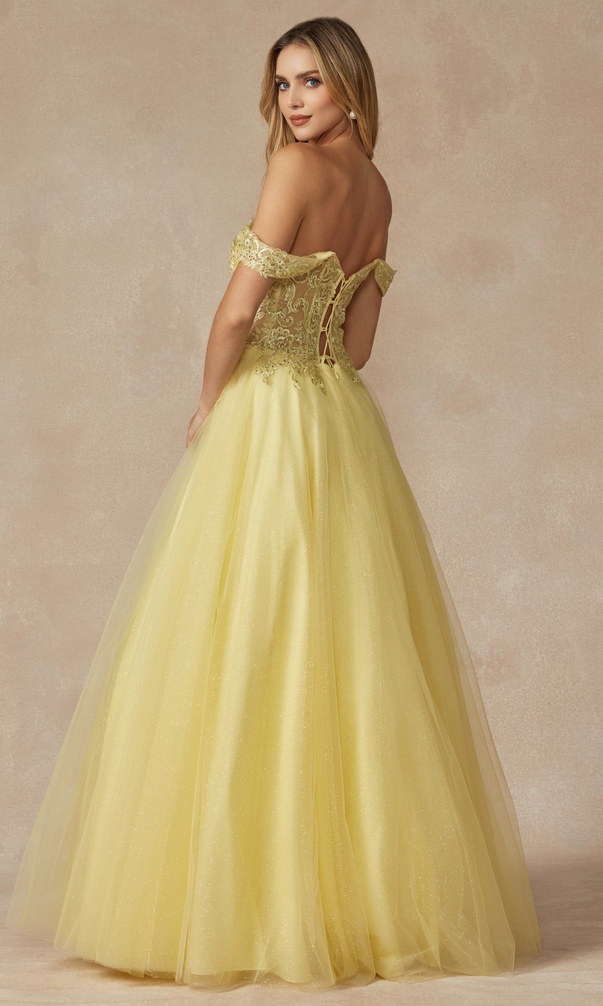 A woman in the Lace-Up Off-Shoulder Long A-Line Prom Dress 280, featuring a lace-up back, stands slightly turned away against a neutral background.
